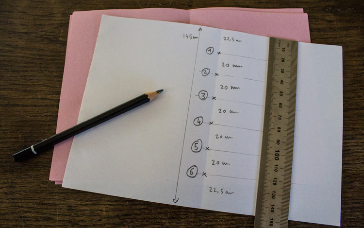 a loose sheet of DIN A5 paper is used as a template for puncturing holes. 6 holes are punctured with a distance of 2cm to each other, centered on the page