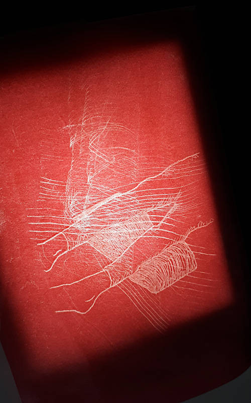 memory foam traces of a tracing with red wax paper. person lying on the floor, the feet lie padded on the memory foam.