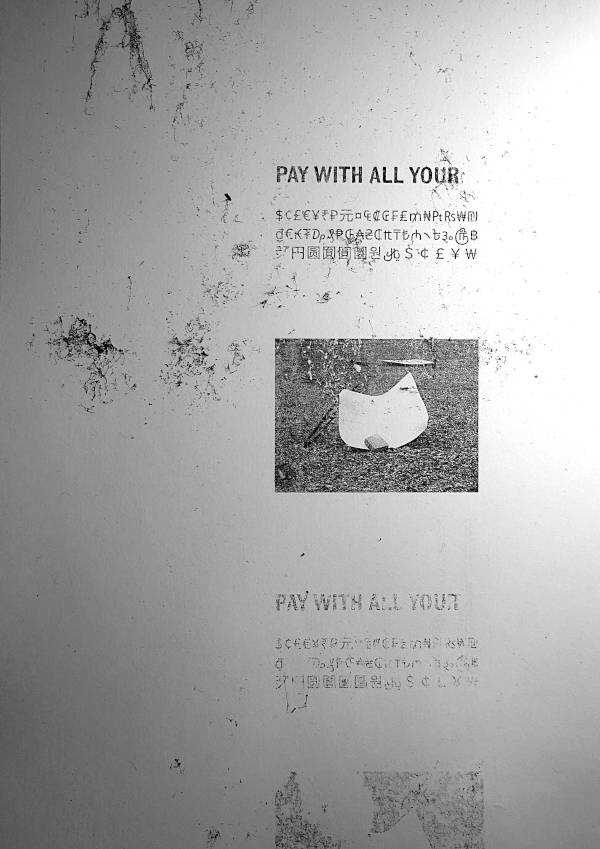 Fallen real estate posters become public sculptures. Motto text “Pay with all your […]” and then a list of various currency symbols. Laser print copy.