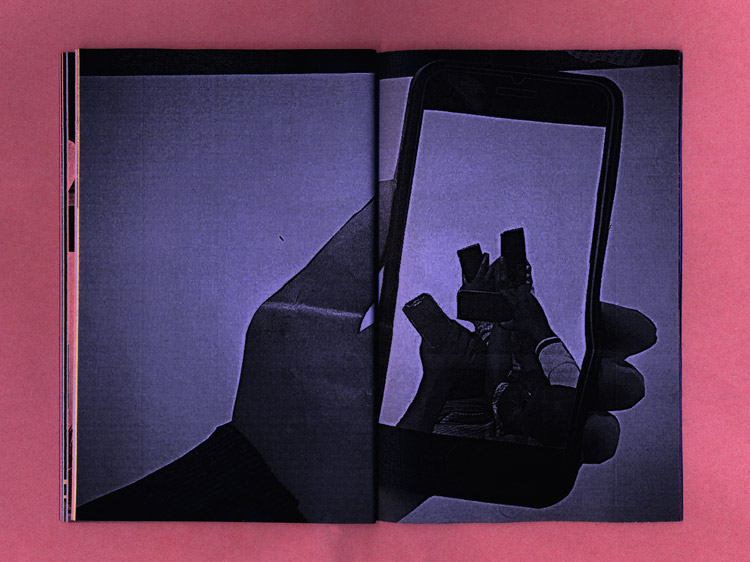 double page, purple paper, a cut out picture of a hand holding a phone. inside the phone another cut out image shows several people holding their phones up to the air