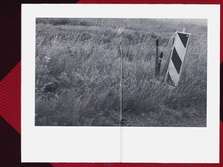grayscale image on a double page in the center of the book, fiber internetcables next to road building sign