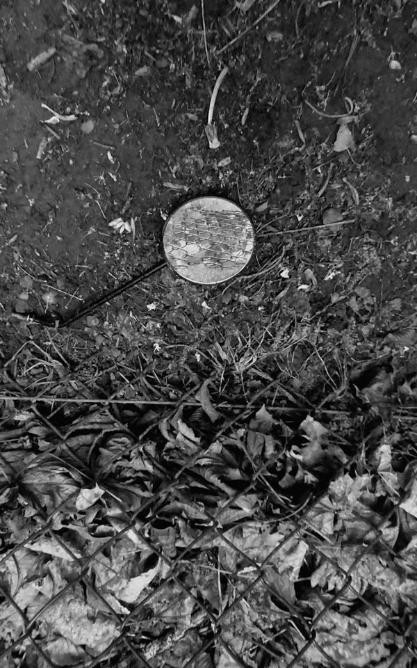 lost mirror on the floor next to a fence